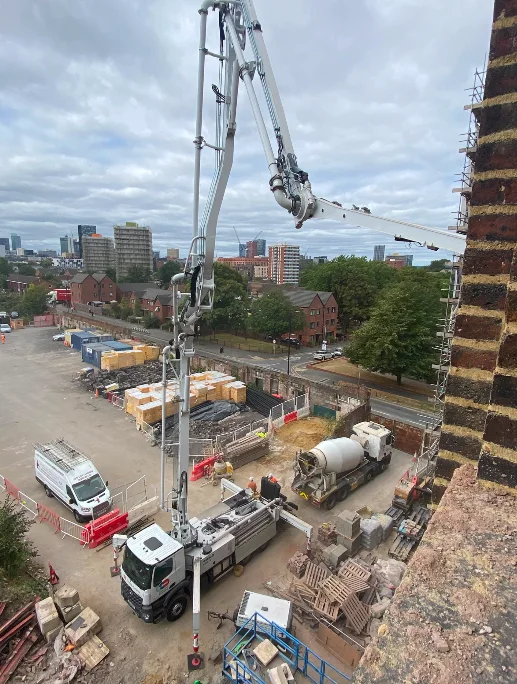 Concrete pump feeding the main lift shafts at Brunswick Mill, Manchester skyline behind
