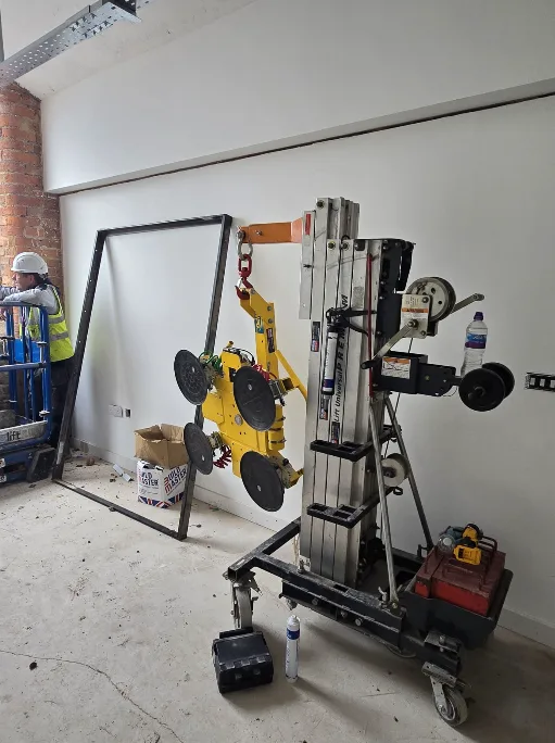 Specialist lifting equipment installing a 132kg triple-glazed window unit at Brunswick Mill